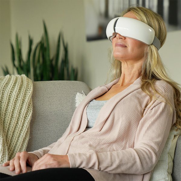 Woman relaxing on couch with Eye Spa on her head.