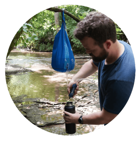 Man using Patriot Pure Personal Water Filter to filter water from a bag