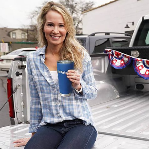 Woman holding 4Patriots stainless steel travel tumbler outside in the bed of a truck