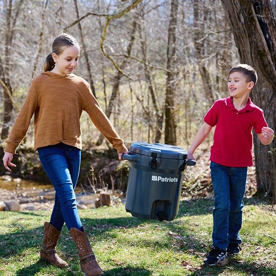 Two kids carrying the Patriot Pure Outdoor Filtration System
