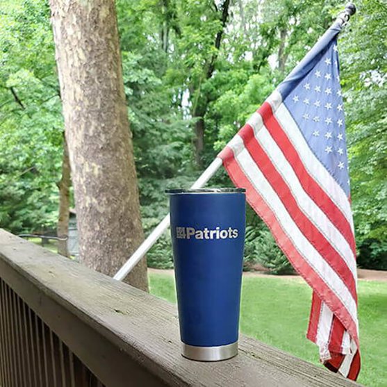 4Patriots stainless steel travel tumbler outside with a flag behind