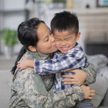 A military mother hugs her son.