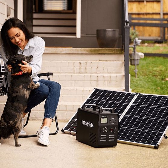Young woman playing with dog next to Patriot Power Generator and solar panel