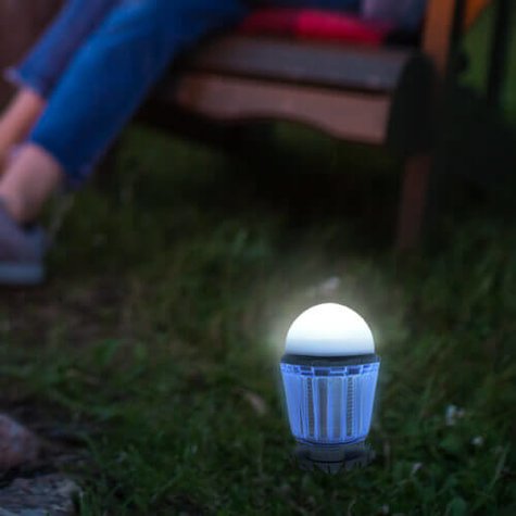 SunBuzz Solar Mosquito Lantern next to a person sitting in a chair outside.