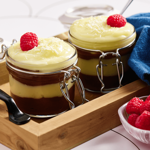 Two desserts in jars with raspberries on top