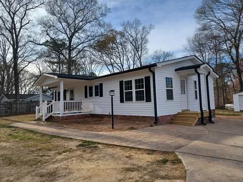 White ranch-style home with black shutters and covered front porch