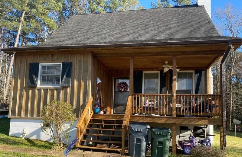 Board-and-batten cabin with covered front porch and wood steps