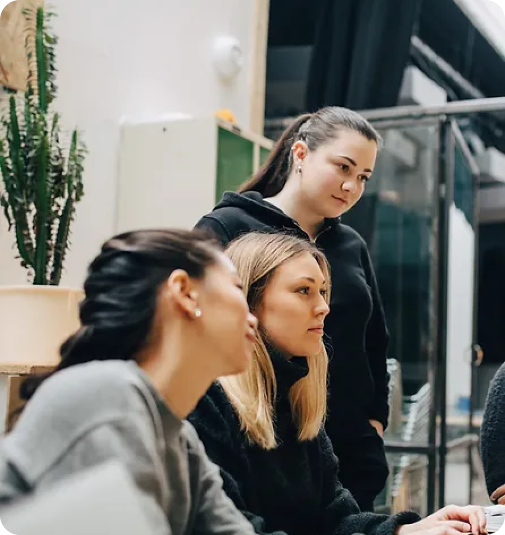 A side view of three people looking at the same screen.