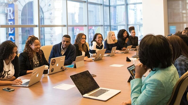 Large team of coworkers gathered around a conference table.