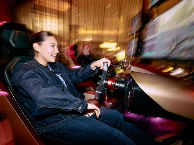 Woman sitting in a sim playing the game at F1 Arcade