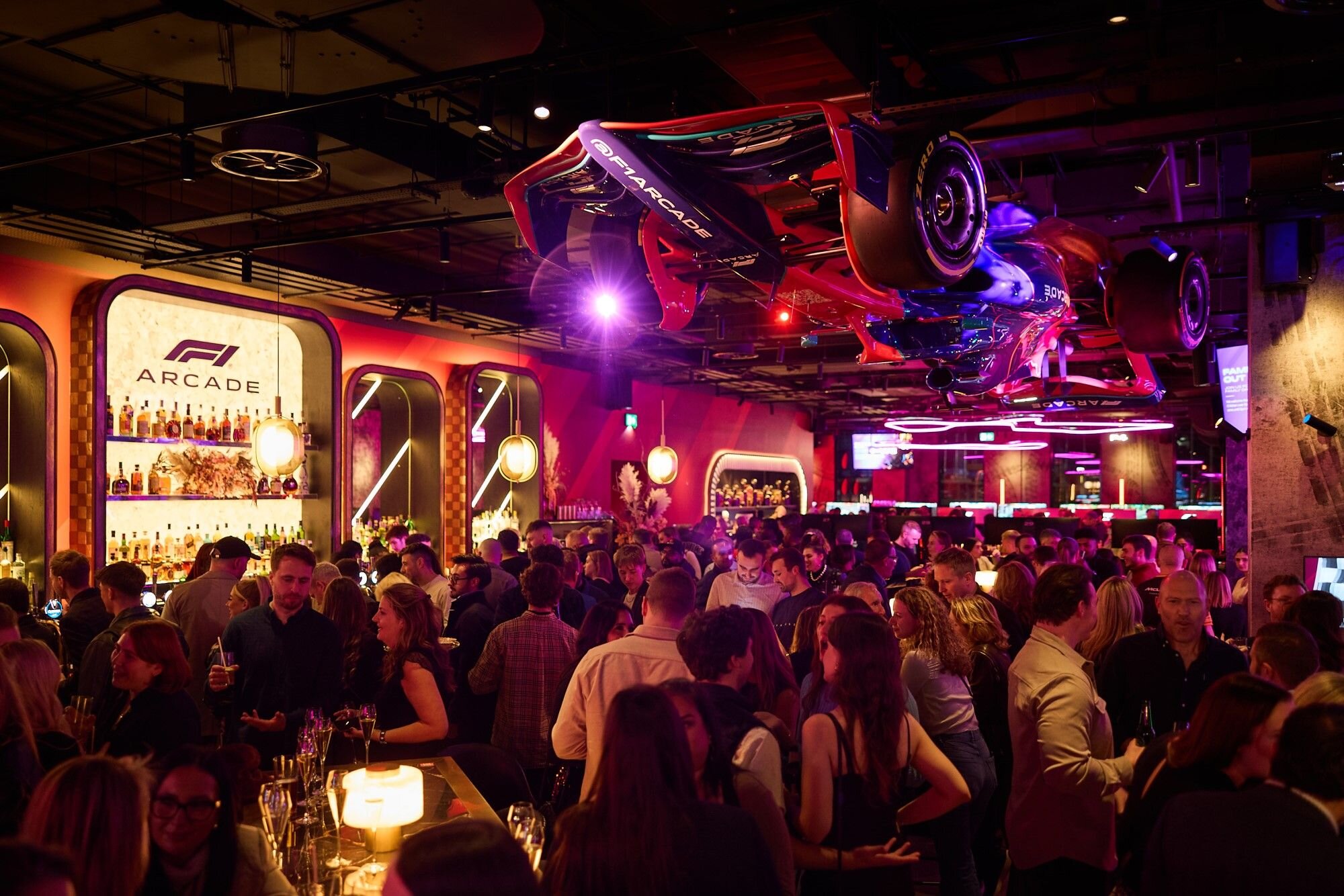 People in F1® Arcade laughing as they race