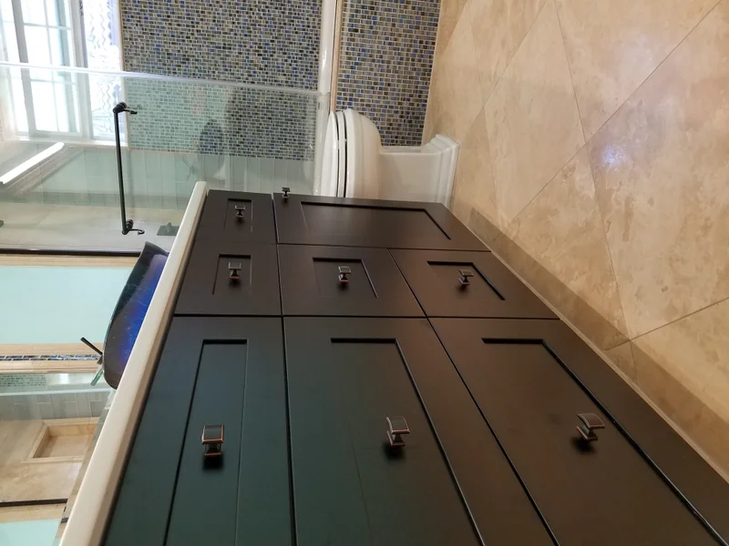 Custom dark bathroom vanity with tiled shower