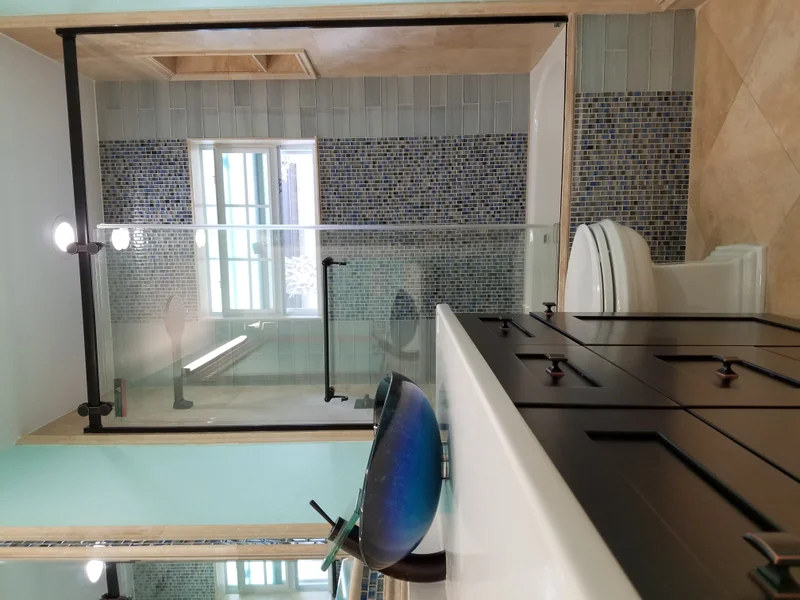 Custom bathroom cabinetry and glass shower enclosure