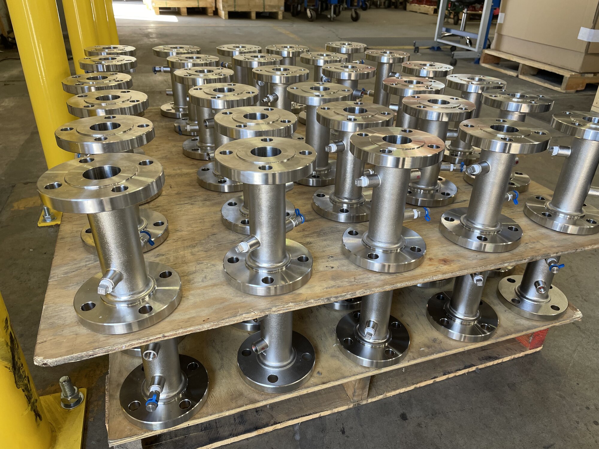 A pallet stacked with numerous stainless steel valves, showcasing their industrial design and functionality.