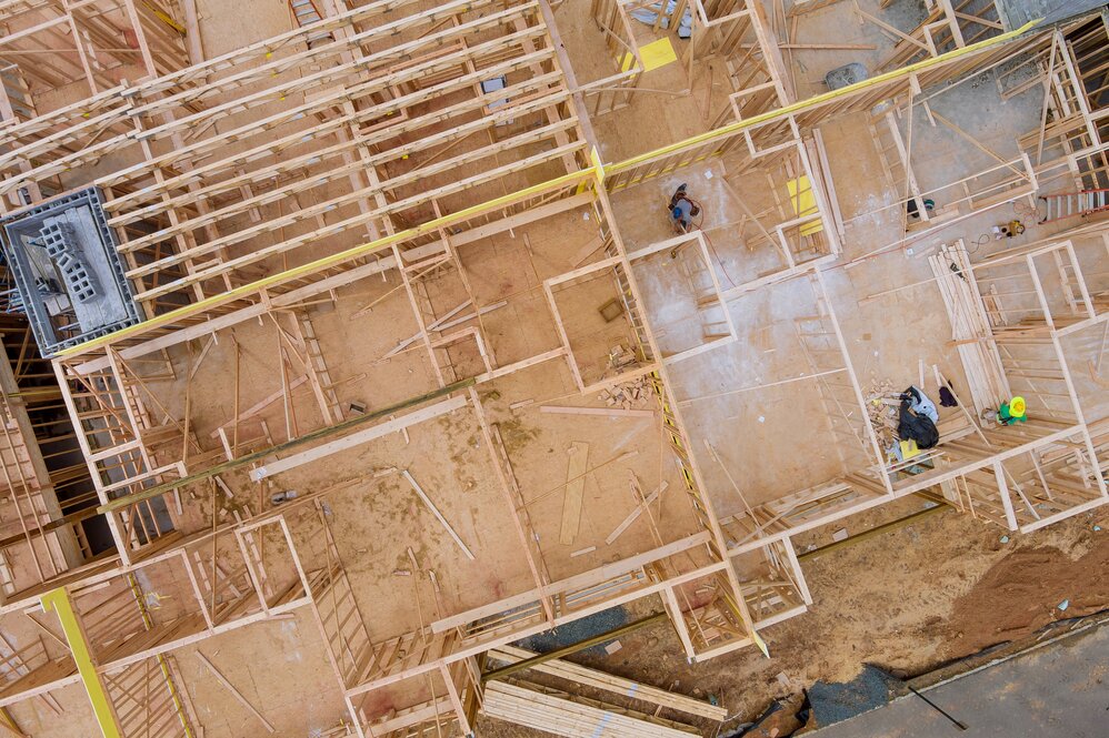 White commercial delivery van driving on a suburban street at sunset. Residential homes, streetlights, and a stop sign are visible.