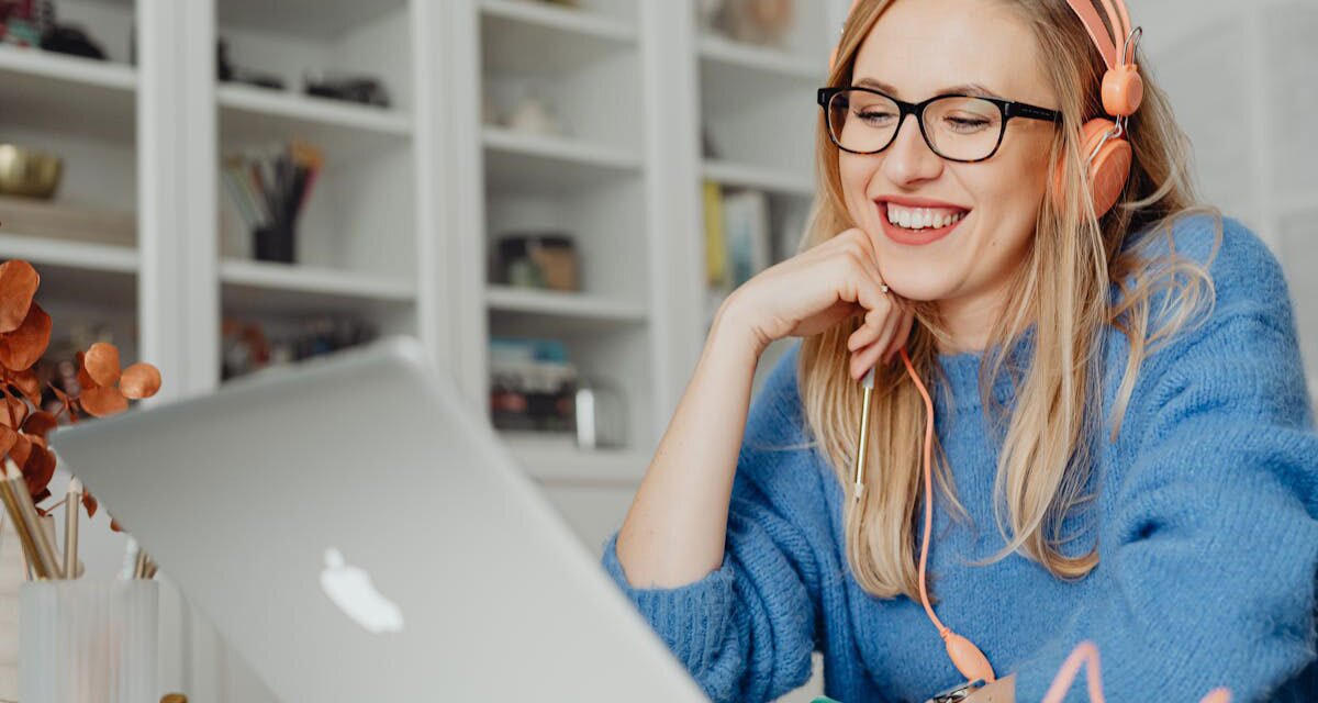 Woman wearing and headphones eyeglasses while using notebook computer