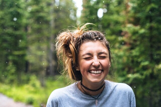 Woman laughing with snowflakes falling around her.