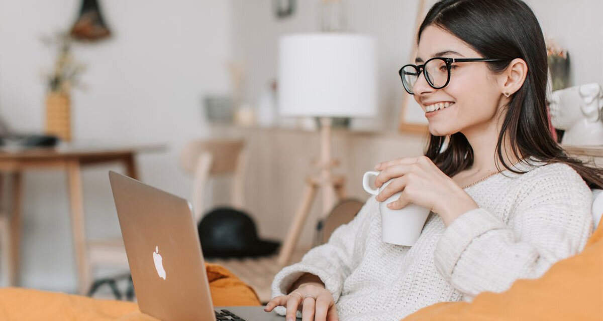 Young woman using a MacBook to apply for a Minute Loan Center personal loan.