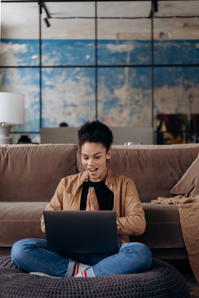Smiling woman reviewing Louisiana line of credit details on a MacBook computer.