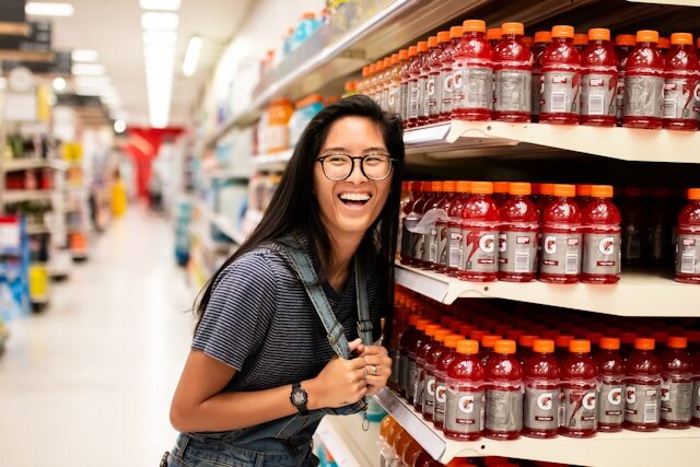 Woman laughing while standing in a supermarket