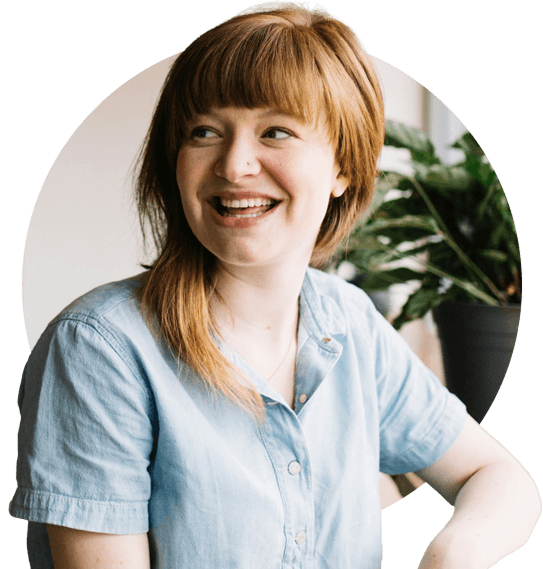 Woman sitting at a table by the window looking away smiling