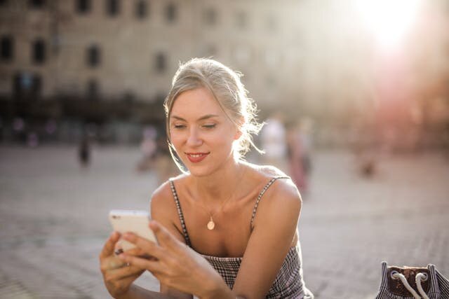 Smiling woman reviewing Wisconsin line of credit on her smartphone.