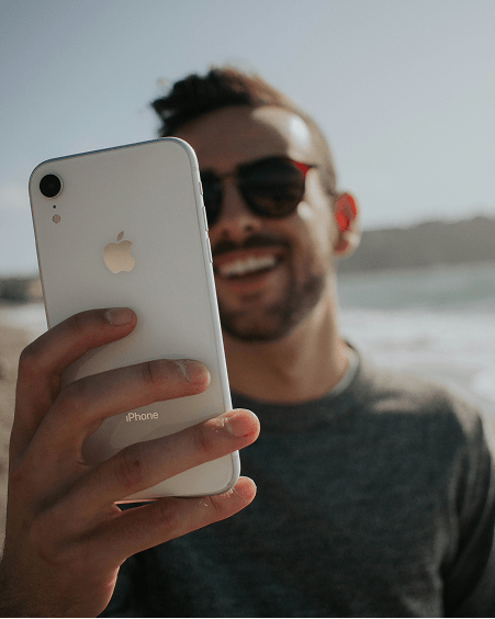 Man using his iPhone on a Delaware beach