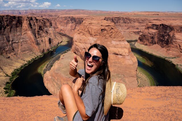 Young woman giving thumbs up near Horseshoe Bend in Utah