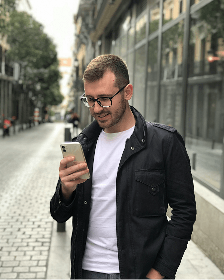 Man standing in street using smartphone