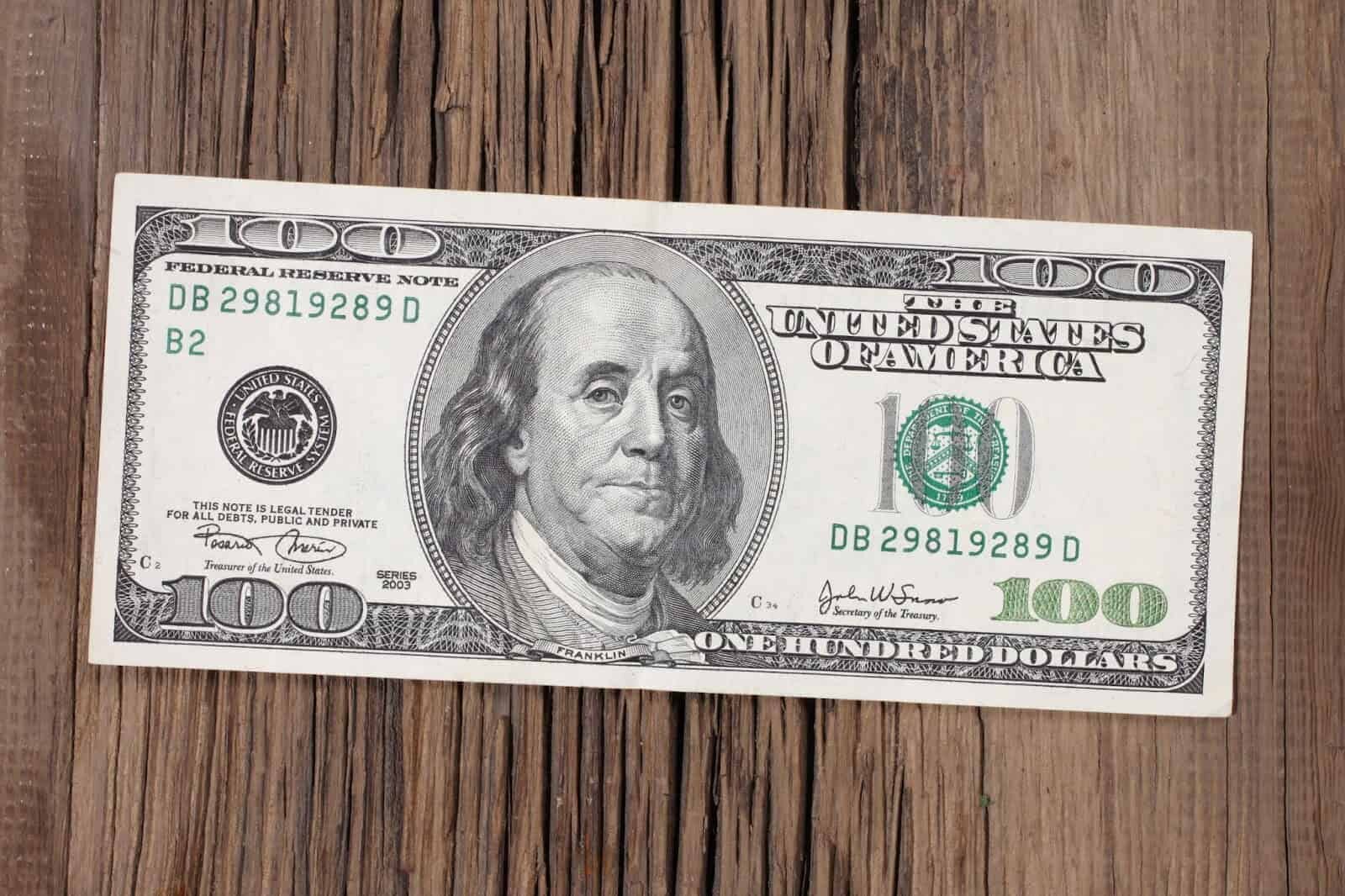 $100 bill on a wooden table