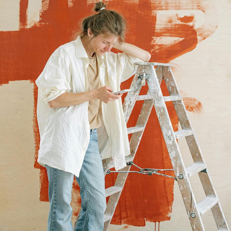 Woman using a phone to apply for a loan during home improvement.