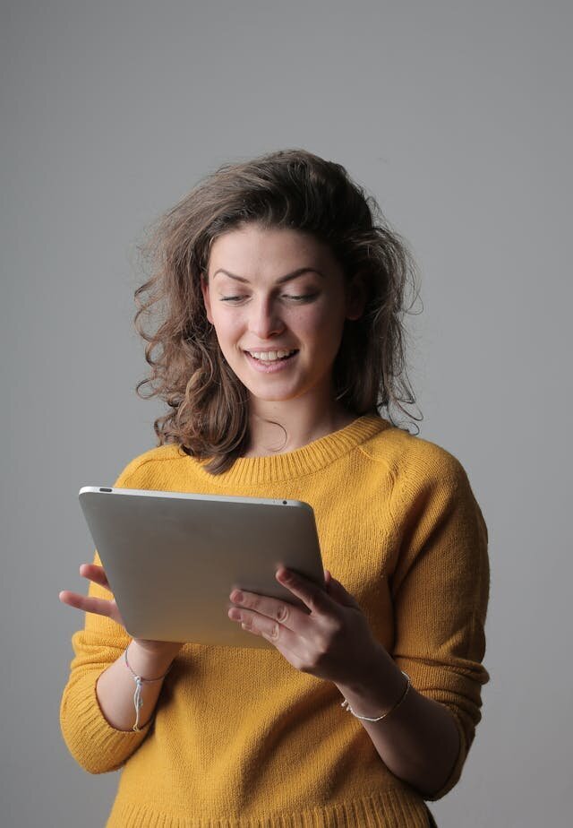 miling woman using tablet to apply for a personal installment loan.