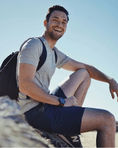 Smiling man sitting on a rock