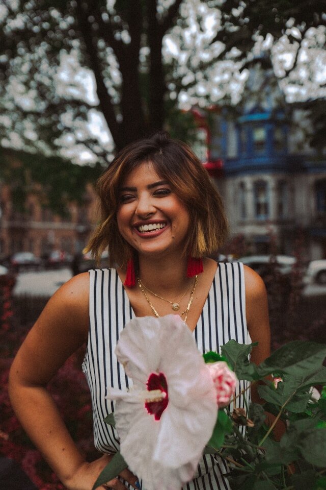 Woman standing next to a flower bush