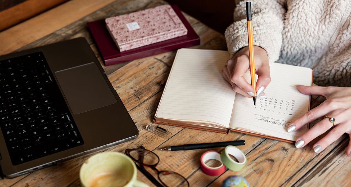 Woman writing in a planner.