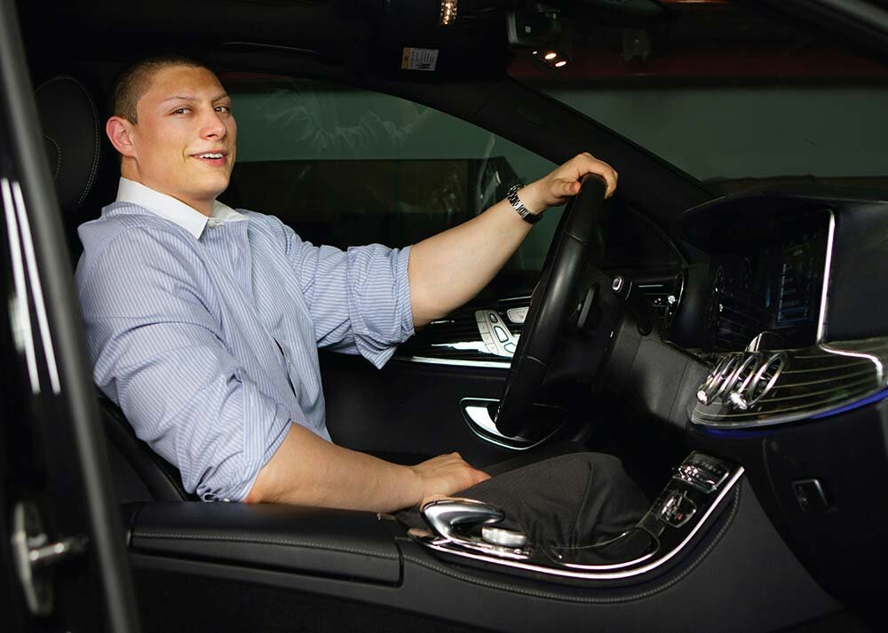 Man driving a luxury vehicle after upgrading his car rental.