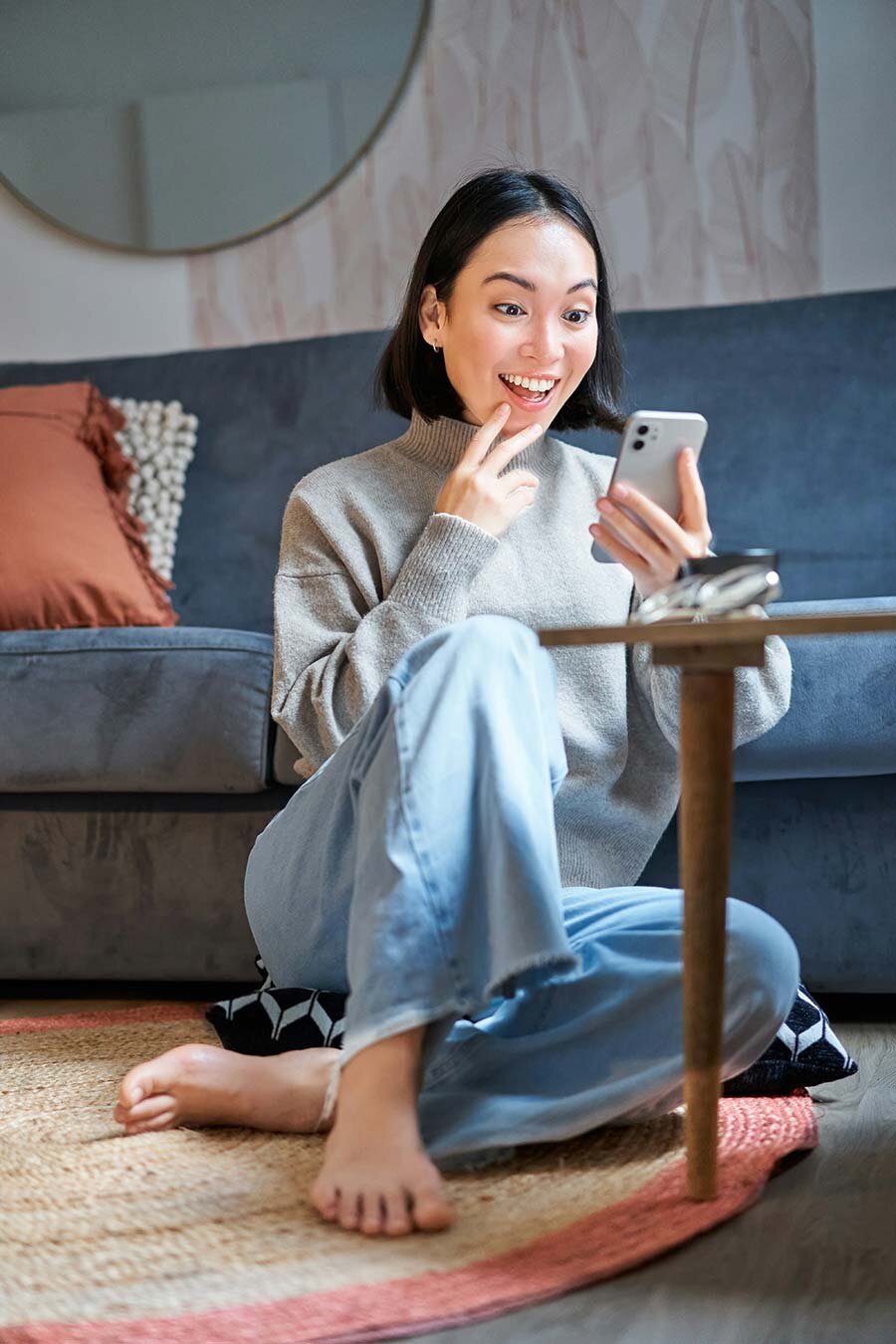 Woman sitting on the floor using a cell phone 