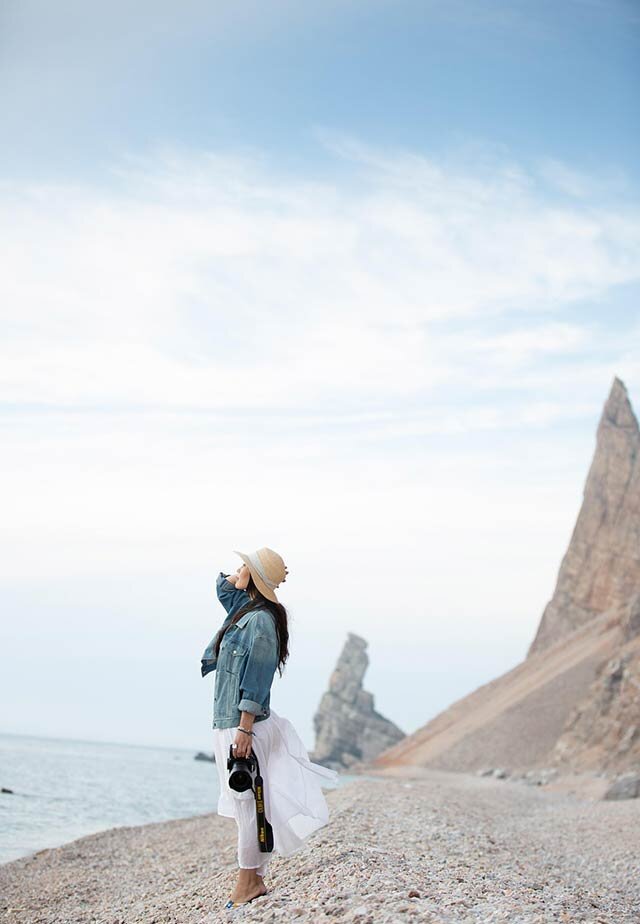 Women standing next to an ocean