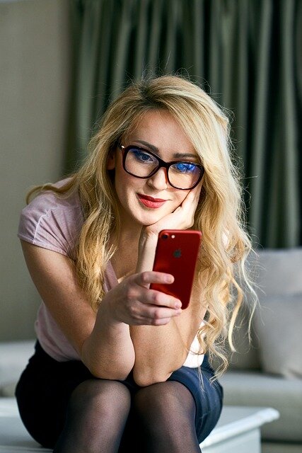 Young woman holding smartphone reading about a line of credit