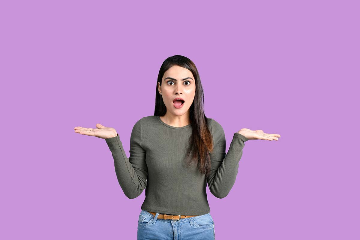 A surprised young woman holding her hands up with palms stretched in wonder