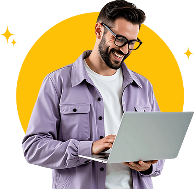 An excited man sitting cross-legged between house plants with a laptop on his lap