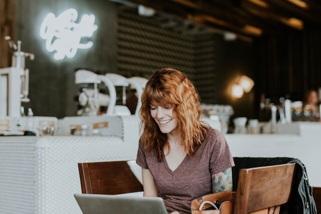 Smiling woman reviewing premier loan approval on her notebook computer.