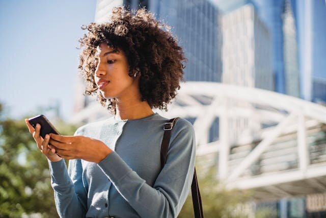 Young woman using phone to browse personal loans in Mississippi