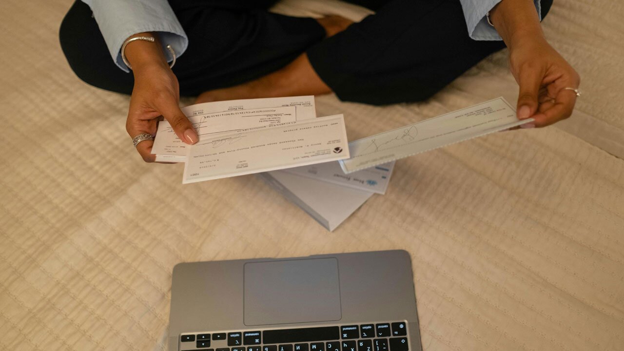 Woman looking through checks earned from a side business.