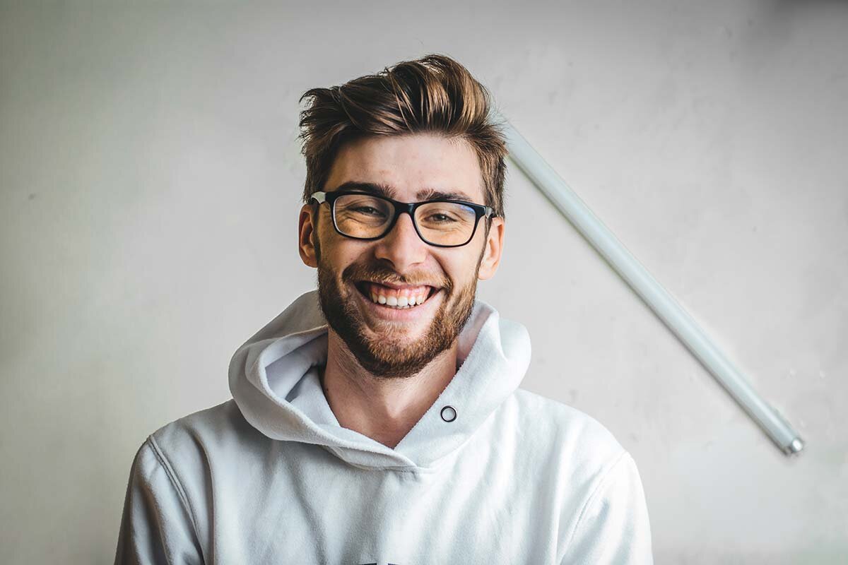 A young man in glasses smiling 