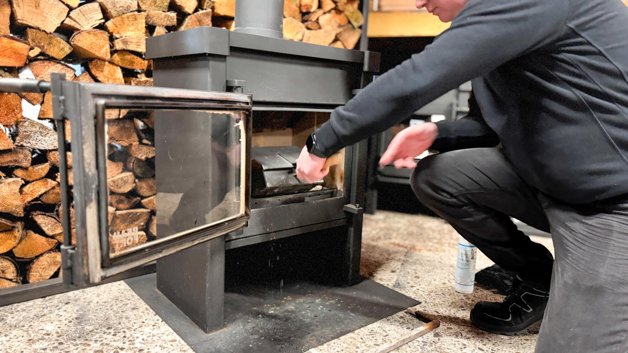 Monteur onderhoudt een houtkachel in de woonkamer – veilig en efficiënt stoken