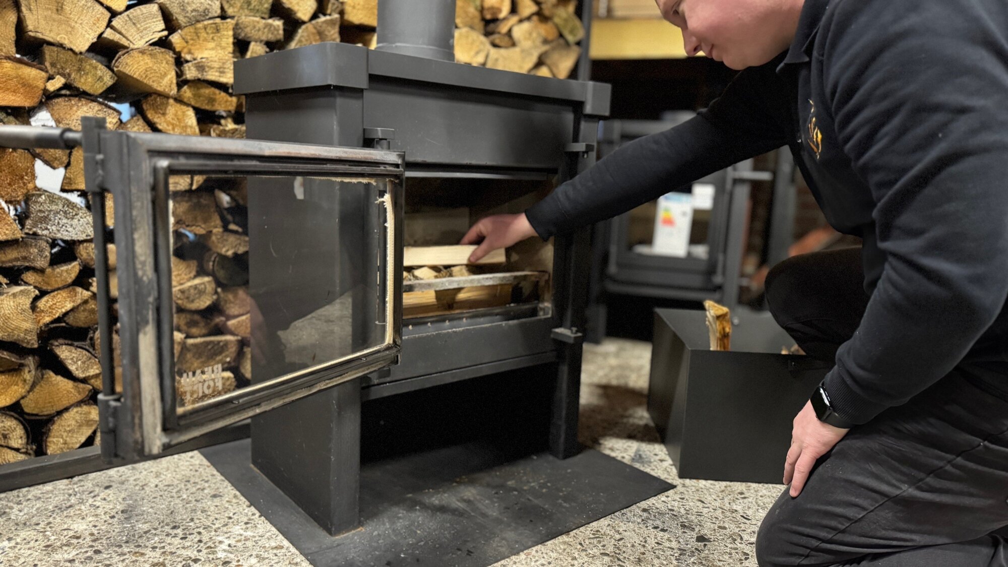 Werknemer stapelt het hout kruislings van groot naar klein in de houtkachel