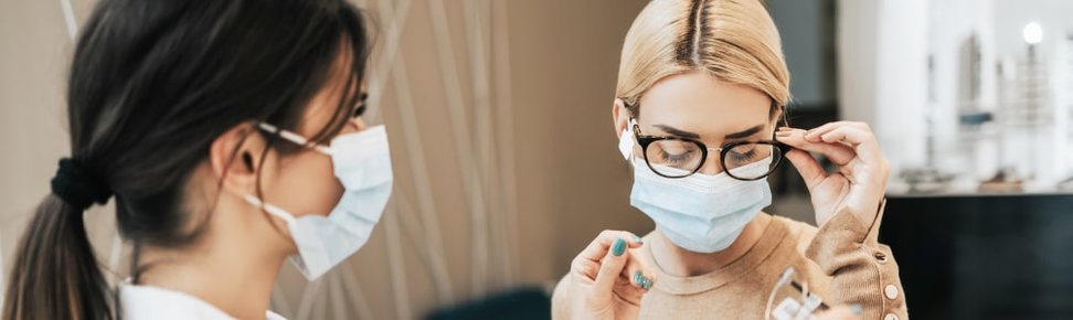 Optometrist and patient wearing face masks for health and safety purposes