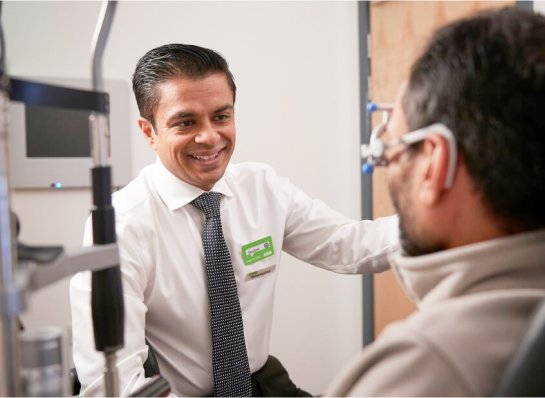 optician checking a patient's eyes during a contact lens aftercare appointment