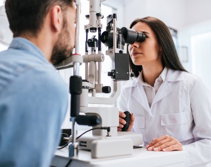 Optician checking a patient's prescription during a contact lens fitting appointment